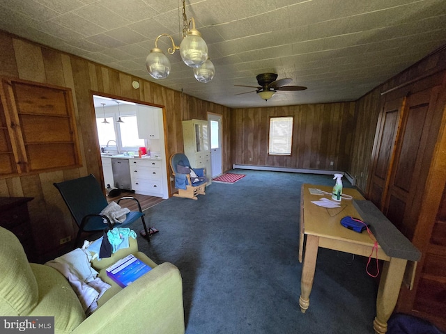 26689 Mariners Rd, Crisfield, MD 21817 - living area with plenty of natural light, wooden walls, dark carpet, baseboard heating, and a ceiling fan