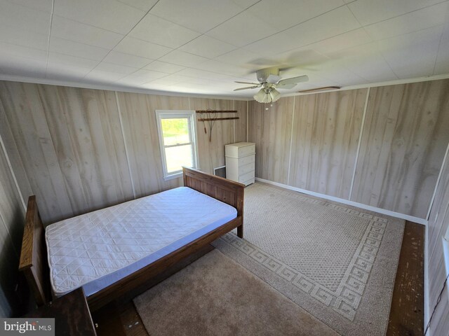 26689 Mariners Rd, Crisfield, MD 21817 - carpeted bedroom with wooden walls and a ceiling fan