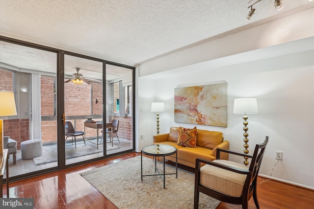1001 N Vermont St Unit 812, Arlington, VA 22201 - living area featuring wood-type flooring, a textured ceiling, a wall of windows, a ceiling fan, and baseboards