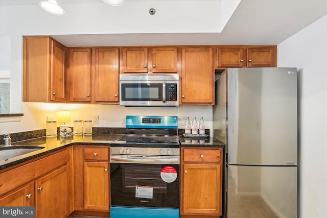 1001 N Vermont St Unit 812, Arlington, VA 22201 - kitchen featuring appliances with stainless steel finishes, brown cabinets, dark stone counters, and a sink