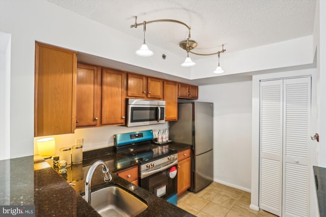 1001 N Vermont St Unit 812, Arlington, VA 22201 - kitchen featuring stainless steel appliances, a sink, brown cabinets, dark stone countertops, and light tile patterned floors
