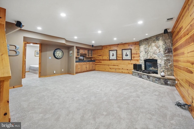 8346 Argent Cir, Fairfax Station, VA 22039 - unfurnished living room featuring recessed lighting, light carpet, wood walls, a stone fireplace, and baseboards