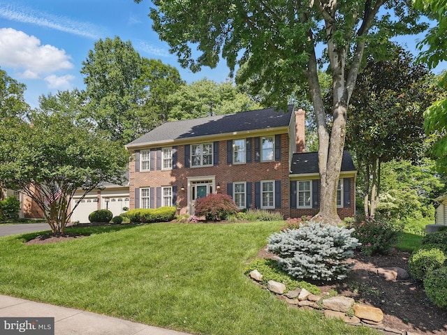 8346 Argent Cir, Fairfax Station, VA 22039 - view of front facade featuring brick siding, a front lawn, an attached garage, and a chimney