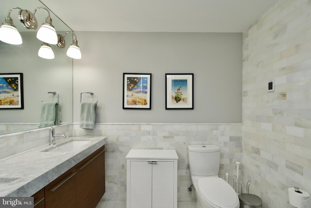 2818 Connecticut Ave NW Unit 503, Washington, DC 20008 - bathroom featuring tile walls, double vanity, toilet, and a wainscoted wall