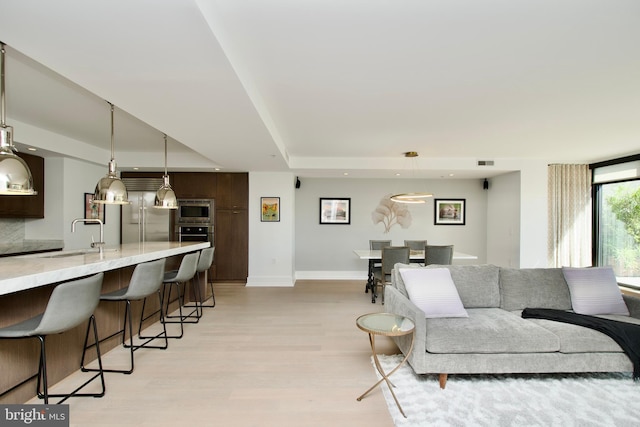 2818 Connecticut Ave NW Unit 503, Washington, DC 20008 - living room featuring a raised ceiling, baseboards, light wood-style floors, and recessed lighting