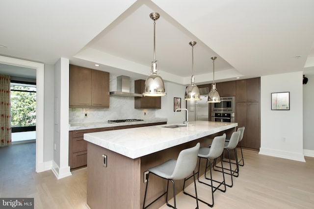 2818 Connecticut Ave NW Unit 503, Washington, DC 20008 - kitchen featuring a raised ceiling, wall chimney range hood, a sink, baseboards, and light wood-type flooring