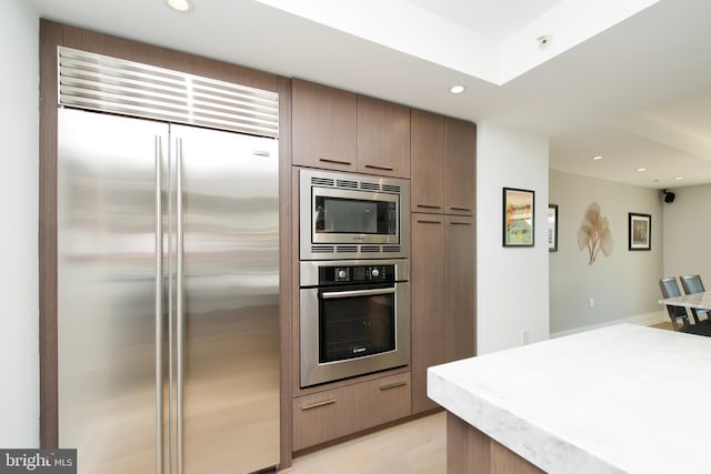 2818 Connecticut Ave NW Unit 503, Washington, DC 20008 - kitchen featuring built in appliances, recessed lighting, light wood finished floors, light countertops, and a skylight