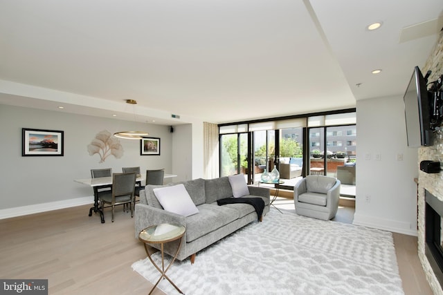 2818 Connecticut Ave NW Unit 503, Washington, DC 20008 - living room with light wood-style floors, a stone fireplace, recessed lighting, and baseboards