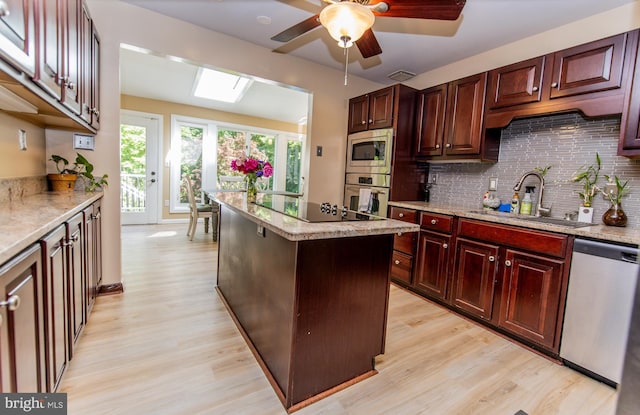 6300 Mallard Ln, Lothian, MD 20711 - kitchen featuring appliances with stainless steel finishes, a sink, light wood-type flooring, and decorative backsplash