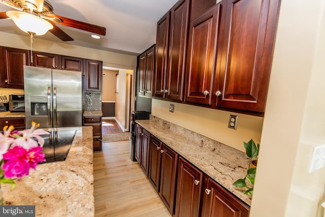 6300 Mallard Ln, Lothian, MD 20711 - kitchen with stainless steel refrigerator with ice dispenser, black electric cooktop, ceiling fan, light wood-style flooring, and light stone counters
