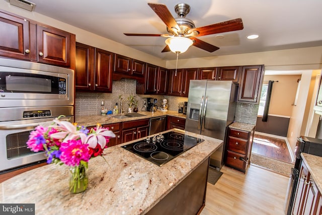 6300 Mallard Ln, Lothian, MD 20711 - kitchen with a sink, appliances with stainless steel finishes, ceiling fan, decorative backsplash, and light wood finished floors