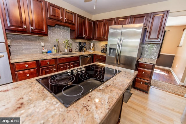 6300 Mallard Ln, Lothian, MD 20711 - kitchen featuring a sink, appliances with stainless steel finishes, reddish brown cabinets, light wood finished floors, and tasteful backsplash