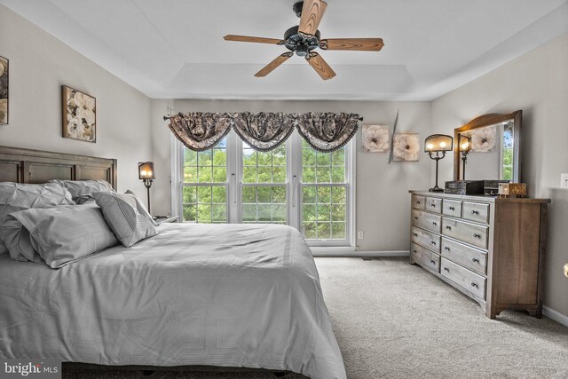 bedroom featuring multiple windows, light carpet, and baseboards
