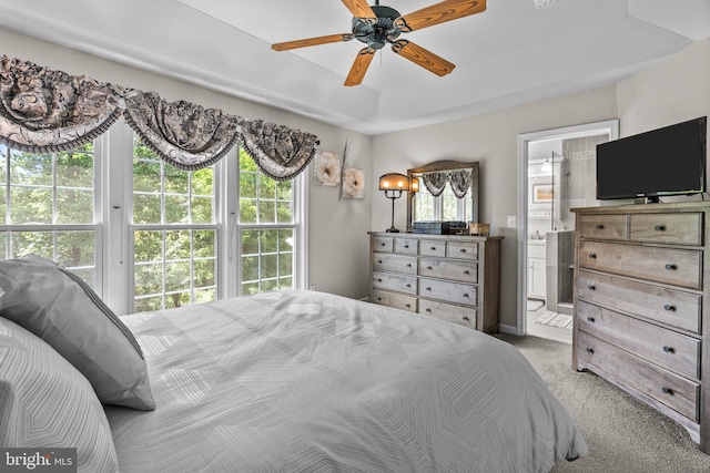 bedroom featuring carpet, ensuite bathroom, and a ceiling fan