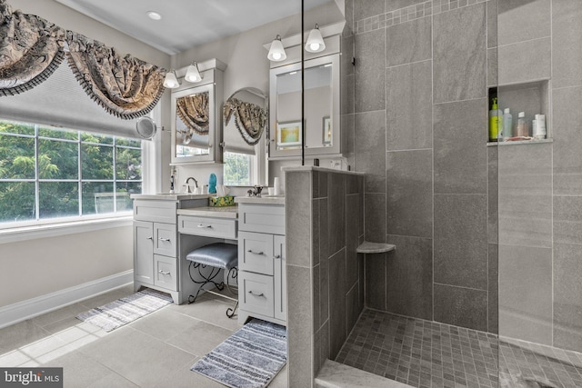 bathroom with tile patterned floors, a walk in shower, vanity, and baseboards