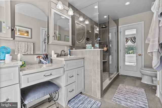full bathroom featuring a tile shower, vanity, tile patterned floors, toilet, and recessed lighting