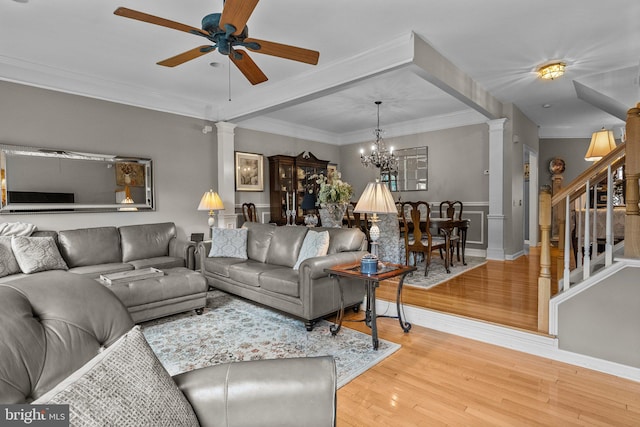 living area featuring decorative columns, a ceiling fan, light wood-style flooring, stairs, and wainscoting