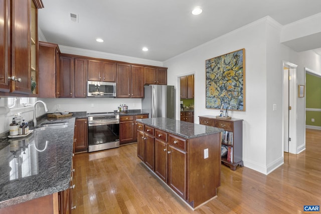 3080 Morewood Ln, Charlottesville, VA 22901 - kitchen featuring stainless steel appliances, a sink, wood finished floors, ornamental molding, and a center island