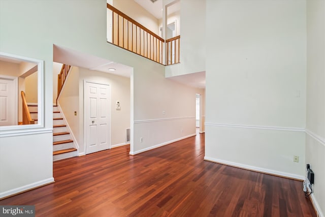 8 Ashford Ct, Annapolis, MD 21403 - empty room featuring a towering ceiling, stairs, wood finished floors, and baseboards
