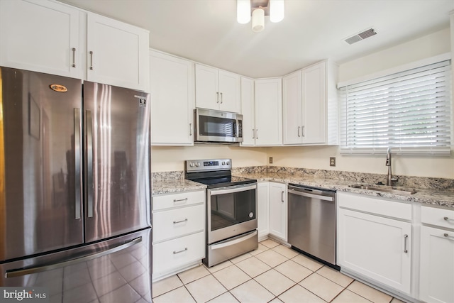 1650 Woodtree Ct E, Annapolis, MD 21409 - kitchen featuring stainless steel appliances, a sink, white cabinetry, light stone countertops, and light tile patterned flooring
