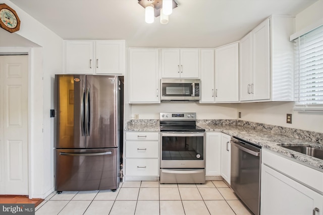 1650 Woodtree Ct E, Annapolis, MD 21409 - kitchen with stainless steel appliances, white cabinets, light stone counters, and light tile patterned floors