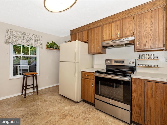 4310 Zircon Rd, Middletown, MD 21769 - kitchen featuring under cabinet range hood, stainless steel electric range, freestanding refrigerator, brown cabinetry, and light countertops