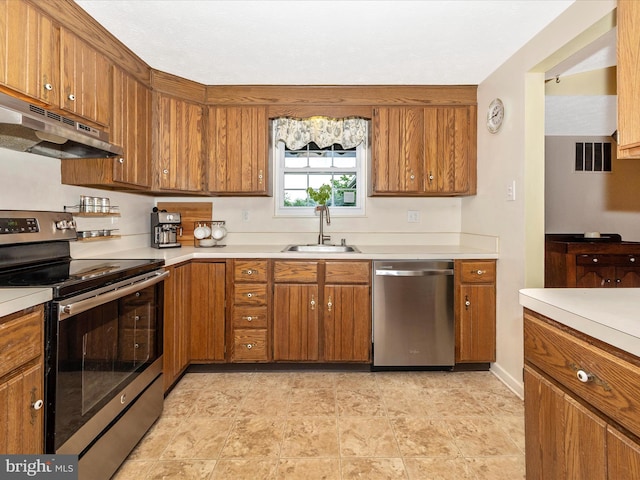 4310 Zircon Rd, Middletown, MD 21769 - kitchen with stainless steel appliances, under cabinet range hood, a sink, brown cabinetry, and light countertops