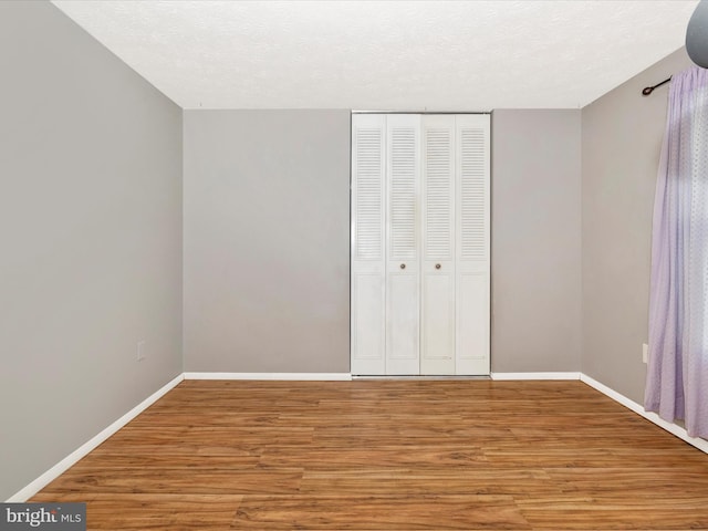 4310 Zircon Rd, Middletown, MD 21769 - unfurnished bedroom featuring wood finished floors, baseboards, a closet, and a textured ceiling