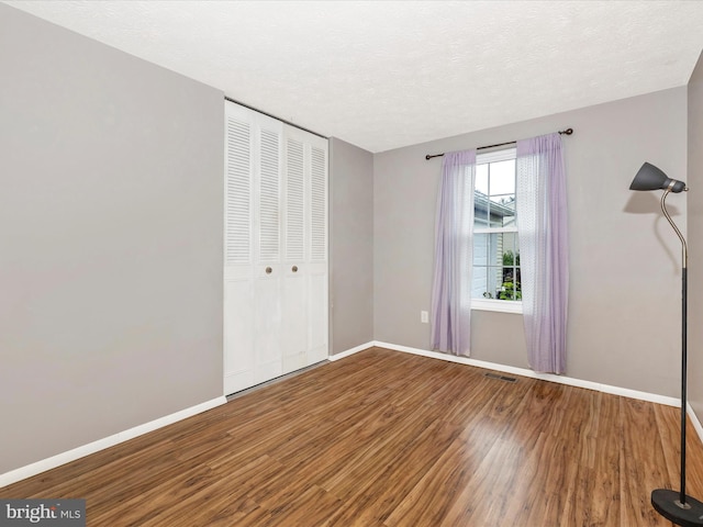 4310 Zircon Rd, Middletown, MD 21769 - unfurnished bedroom featuring wood finished floors, a closet, baseboards, and a textured ceiling