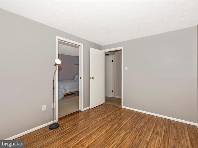 4310 Zircon Rd, Middletown, MD 21769 - unfurnished bedroom with wood finished floors, baseboards, a closet, and a textured ceiling