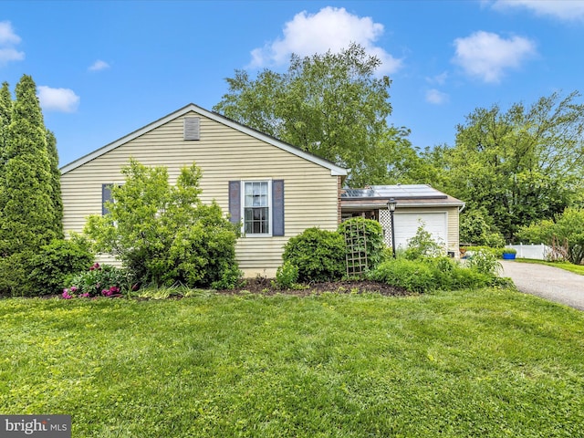 4310 Zircon Rd, Middletown, MD 21769 - view of home's exterior featuring roof mounted solar panels, asphalt driveway, a garage, and a yard