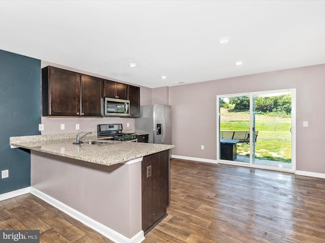 11044 Cross Fields Dr, Waynesboro, PA 17268 - kitchen with stainless steel appliances, dark brown cabinets, dark wood-style flooring, a peninsula, and light stone counters
