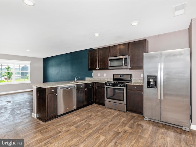 11044 Cross Fields Dr, Waynesboro, PA 17268 - kitchen with appliances with stainless steel finishes, light wood-type flooring, dark brown cabinets, a peninsula, and recessed lighting