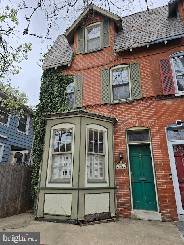 807 W 10th St, Wilmington, DE 19801 - view of front facade featuring brick siding, a garage, fence, and a high end roof