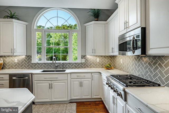 201 Ivystone Dr, Downingtown, PA 19335 - kitchen featuring appliances with stainless steel finishes, a sink, white cabinetry, light stone countertops, and tasteful backsplash