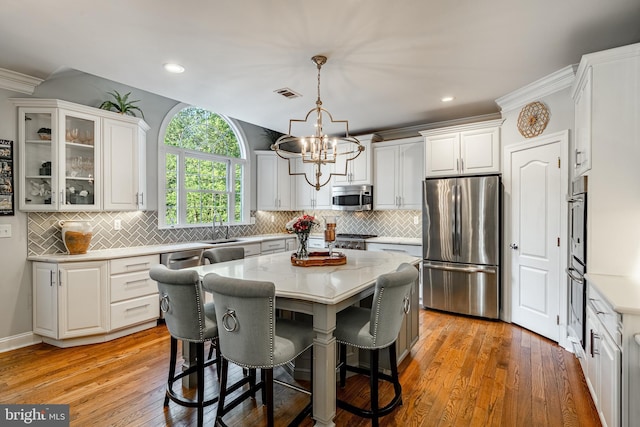 201 Ivystone Dr, Downingtown, PA 19335 - kitchen with appliances with stainless steel finishes, white cabinetry, a chandelier, recessed lighting, and ornamental molding