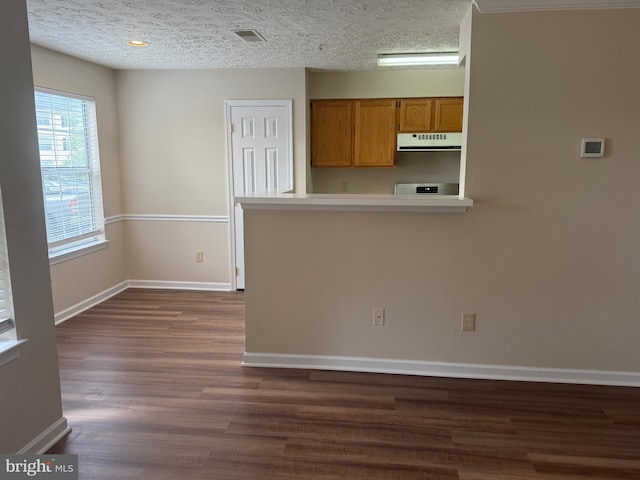 11002 Koman Cir, Manassas, VA 20109 - kitchen with exhaust hood, brown cabinetry, dark wood finished floors, baseboards, and light countertops