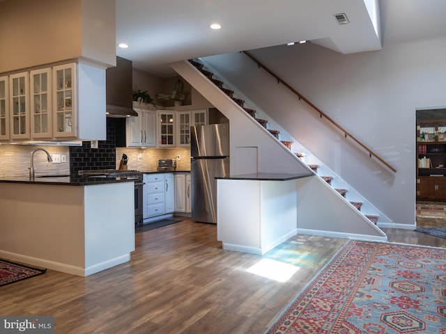 5607 Meridian Rd, Gibsonia, PA 15044 - kitchen with stainless steel appliances, dark countertops, dark wood finished floors, a peninsula, and tasteful backsplash