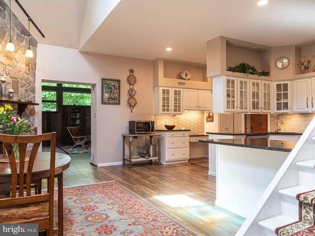 5607 Meridian Rd, Gibsonia, PA 15044 - kitchen with wood finished floors, tasteful backsplash, white cabinets, stainless steel microwave, and glass insert cabinets