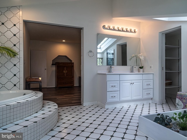 5607 Meridian Rd, Gibsonia, PA 15044 - bathroom featuring a skylight, tile patterned floors, vanity, and tiled tub