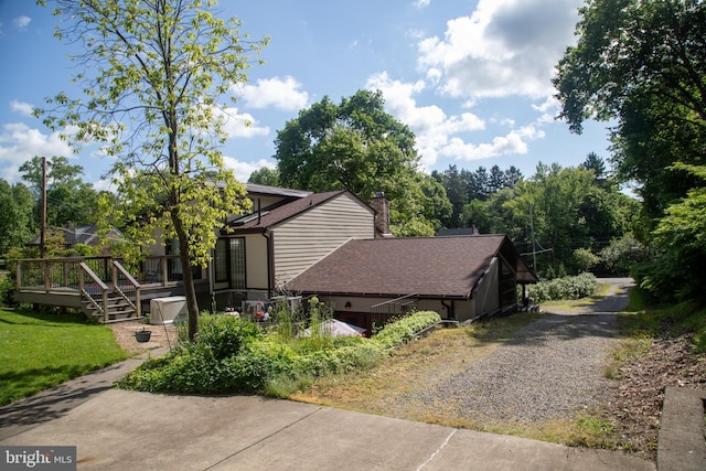 5607 Meridian Rd, Gibsonia, PA 15044 - view of home's exterior with a deck, gravel driveway, a shingled roof, and a chimney