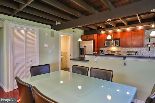 dining space with beam ceiling, dark wood finished floors, and baseboards