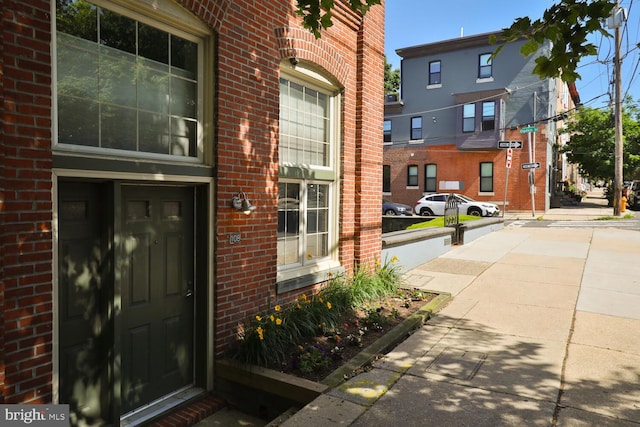 view of exterior entry featuring brick siding