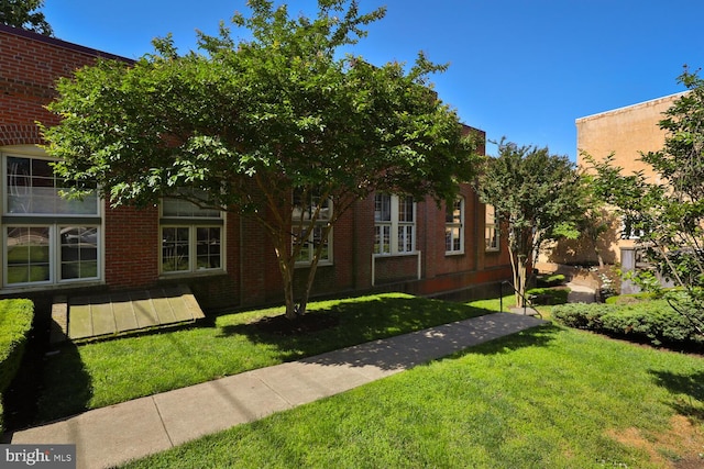view of front of home featuring a front yard and brick siding