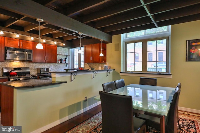 dining room featuring baseboards, wood finished floors, track lighting, and beam ceiling