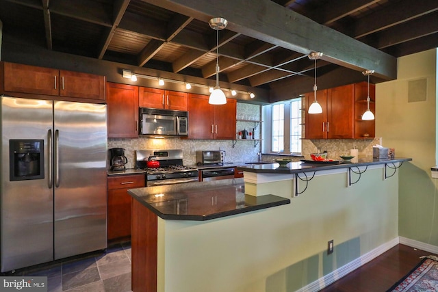 kitchen featuring stainless steel appliances, dark countertops, a peninsula, beam ceiling, and tasteful backsplash