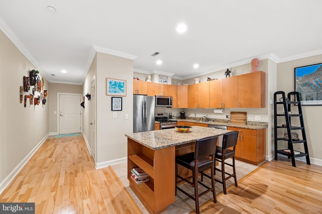 2007 Clipper Park Rd Unit 114, Baltimore, MD 21211 - kitchen featuring appliances with stainless steel finishes, light wood-style floors, recessed lighting, ornamental molding, and a center island