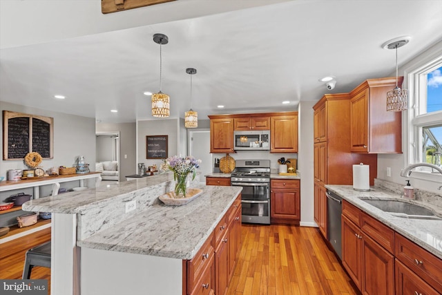 34602 Roxana Rd, Frankford, DE 19945 - kitchen featuring appliances with stainless steel finishes, a sink, recessed lighting, light stone counters, and light wood-style flooring