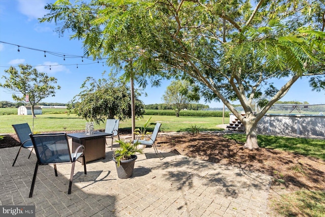 34602 Roxana Rd, Frankford, DE 19945 - view of patio / terrace featuring a shed, an outbuilding, and an outdoor fire pit