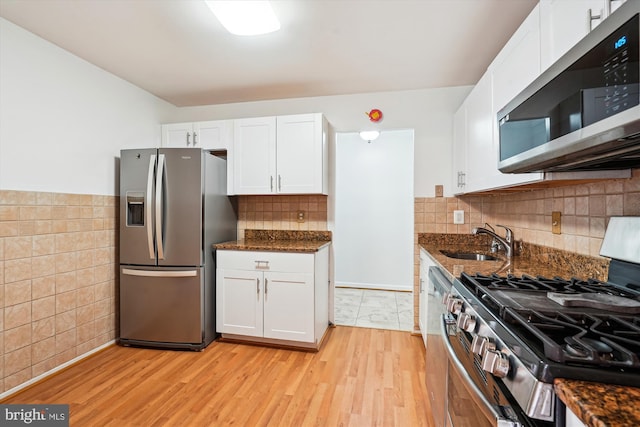 19439 Brassie Pl Unit 101, Gaithersburg, MD 20886 - kitchen with appliances with stainless steel finishes, a sink, white cabinets, dark stone counters, and tile walls